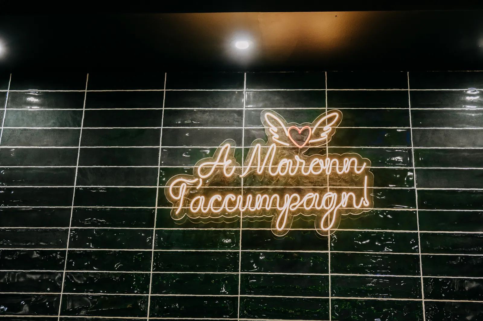 Atmosphärischer Neon-Schriftzug an der Backsteinwand